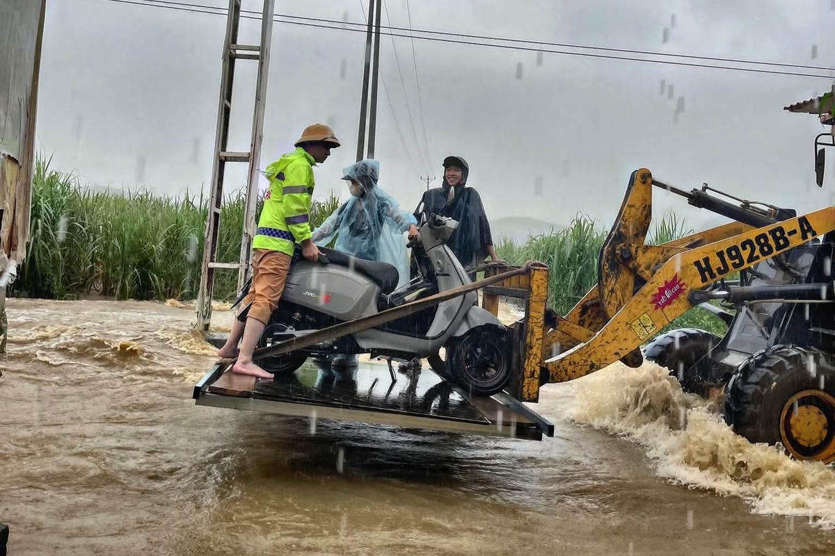 CSGT hỗ trợ đưa phương tiện qua khu vực điểm tràn chảy xiết ở xã Ngọc Trạo. Ảnh: Thành Cháo