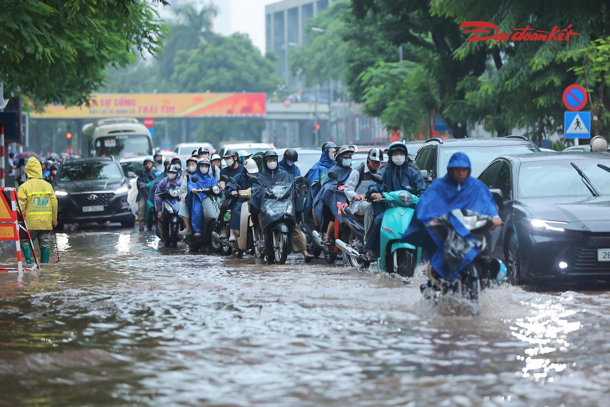 Do ngập xảy ra đúng thời điểm người dân đi làm, lượng phương tiện qua phố Thái Hà bị ùn ứ. Nhiều người phải bì bõm di chuyển qua đoạn đường ngập để tiếp tục hành trình.