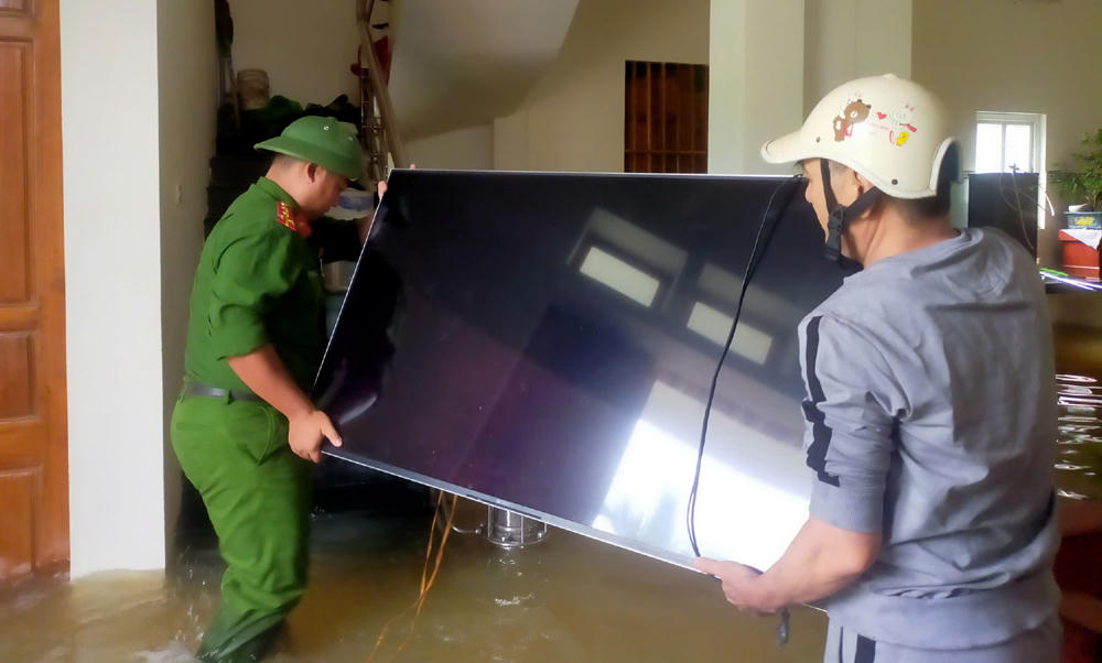 Công an xã Kim Tân hỗ trợ người dân di dời tài sản đến nơi an toàn. Ảnh: CAX Kim Tân