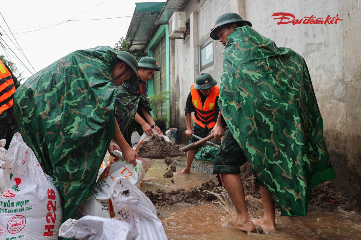Bộ đội phụ giúp người dân ứng phó với tình trạng ngập úng.