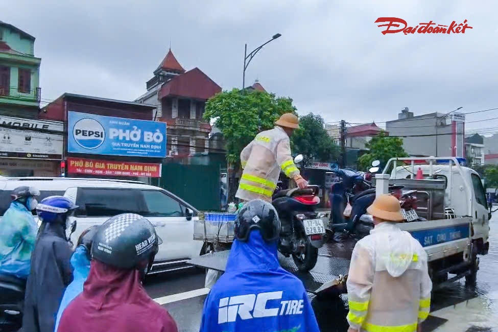 Đội CSGT đường bộ số 9 sử dụng xe tải chuyên dụng hỗ trợ người dân và phương tiện qua khu vực ngập sâu trên Quốc lộ 32.