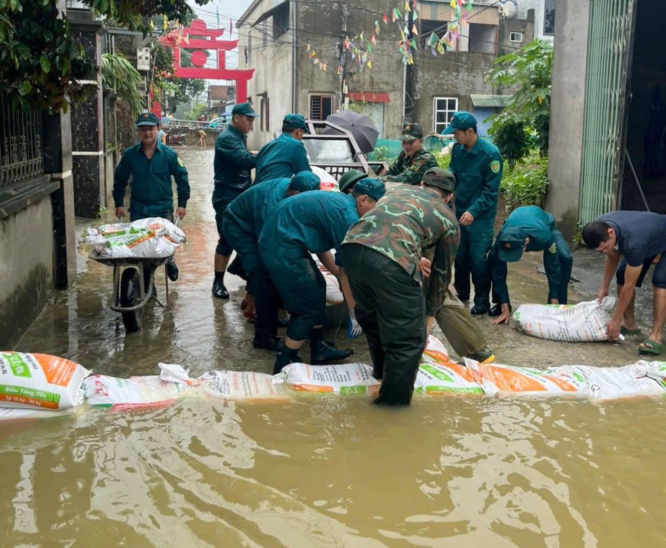 Hàng trăm cán bộ, chiến sĩ công an, quân đội chống lũ sông Bùi tràn vào khu dân cư ở xã Quảng Bị. Ảnh: Vũ Liên
