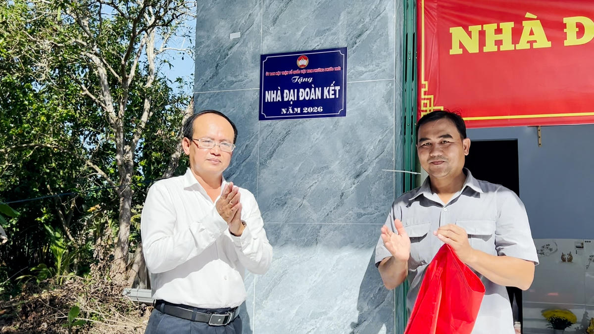 Ông Trần Văn Xem - Phó Bí thư Thường trực Đảng ủy phường Phước Thới (bên trái) cùng ông Nguyễn Dũng Phương, khu vực Bình An thực hiện nghi thức bàn giao nhà