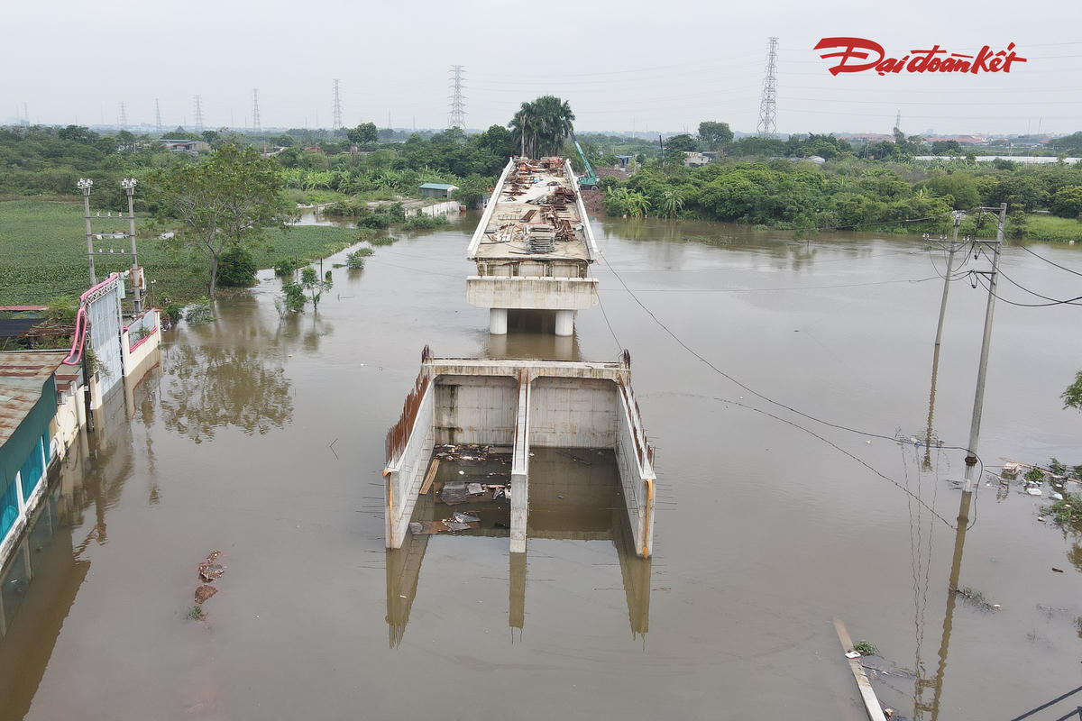 Nước ngập cầu Tân Phú, bên cạnh là cầu Tân Phú mới đang được xây dựng nhưng chưa hoàn thiện, chưa thể đưa vào sử dụng.
