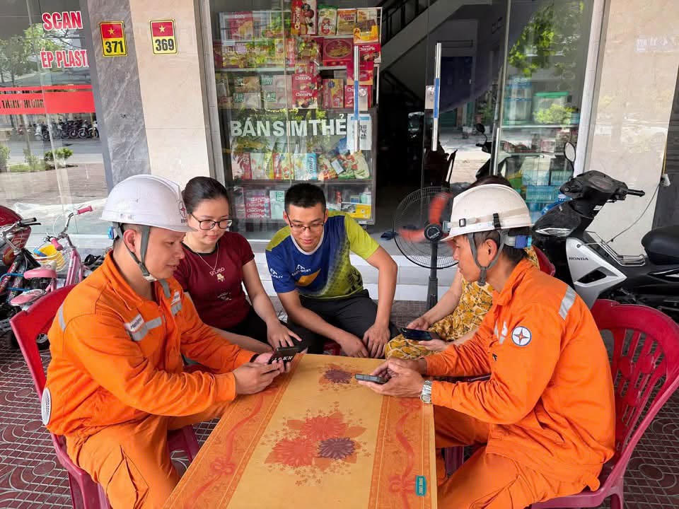 Nhân viên Điện lực Đông Triều, CTĐL Quảng Ninh tuyên truyền, hướng dẫn khách hàng cài đặt ứng dụng EVN CSKH