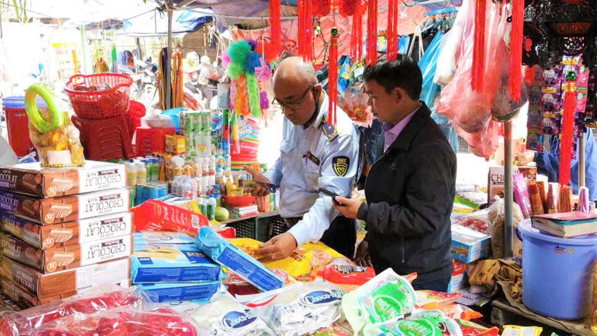 Lực lượng chức năng kiểm tra an toàn thực phẩm các loại bánh kẹo tại cửa hàng. Ảnh: QL.