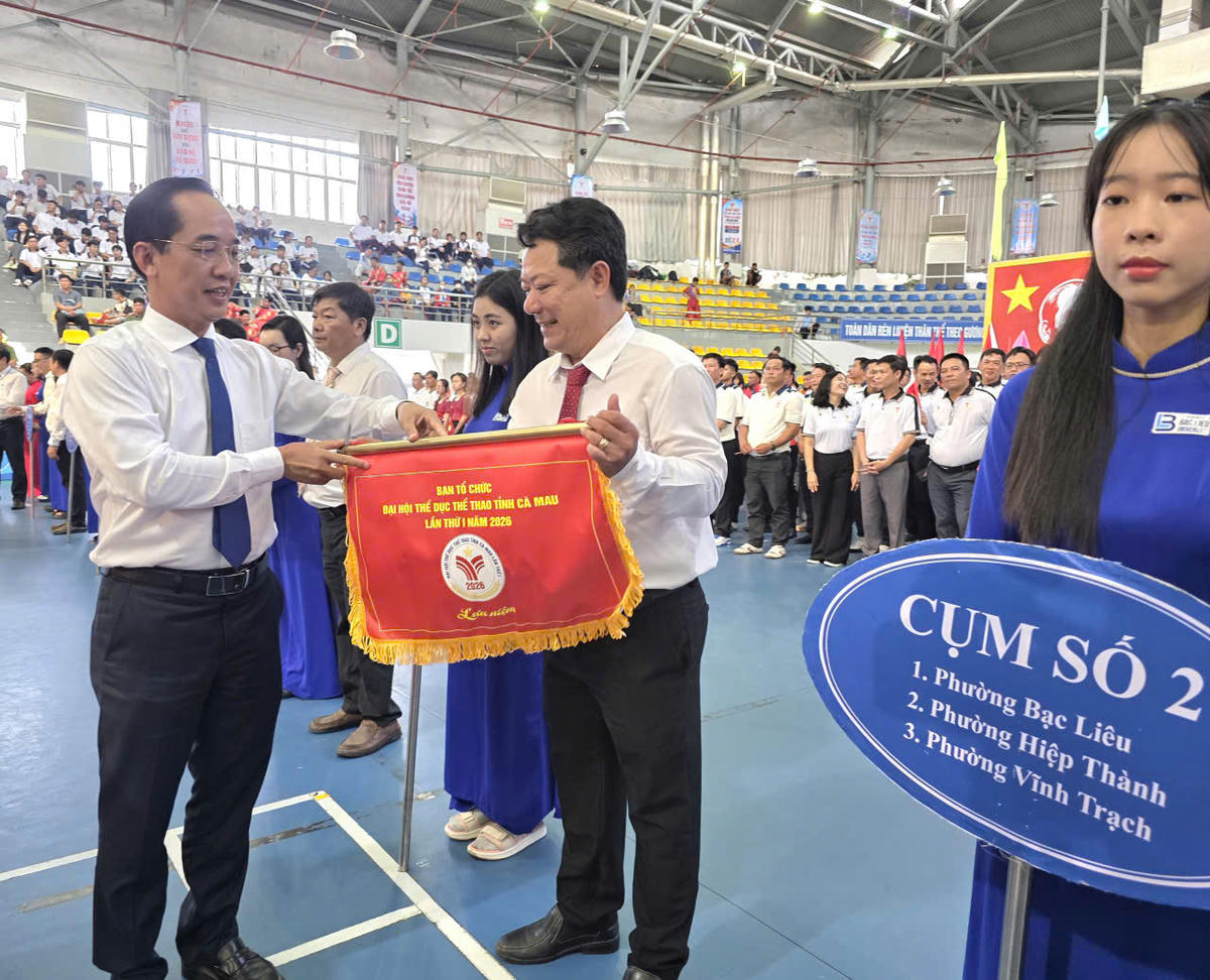 Phó Bí thư Tỉnh ủy, Chủ tịch Ủy ban MTTQ Việt Nam tỉnh Cà Mau Hồ Thanh Thủy tặng cờ lưu niệm cho các đoàn tham dự đại hội. Ảnh: Nguyên Du