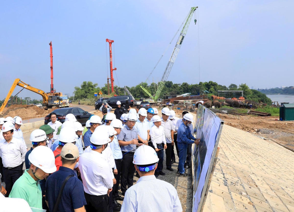 Đoàn công tác nghe báo cáo việc triển khai Dự án đầu tư xây dựng cầu Tứ Liên và đường hai đầu cầu. Ảnh: VT