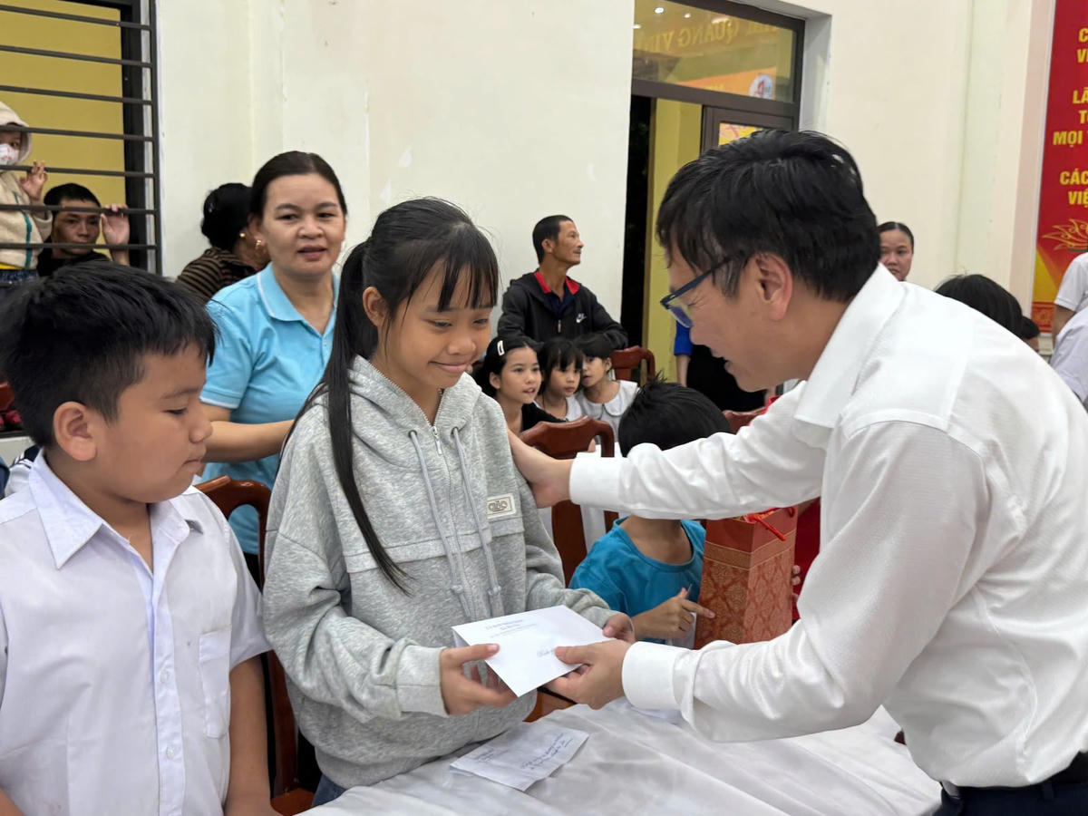 Phó Bí thư Thường trực Đảng ủy xã Bà Nà Bùi Nam Dũng tặng quà cho trẻ em. Ảnh: Công Dân.