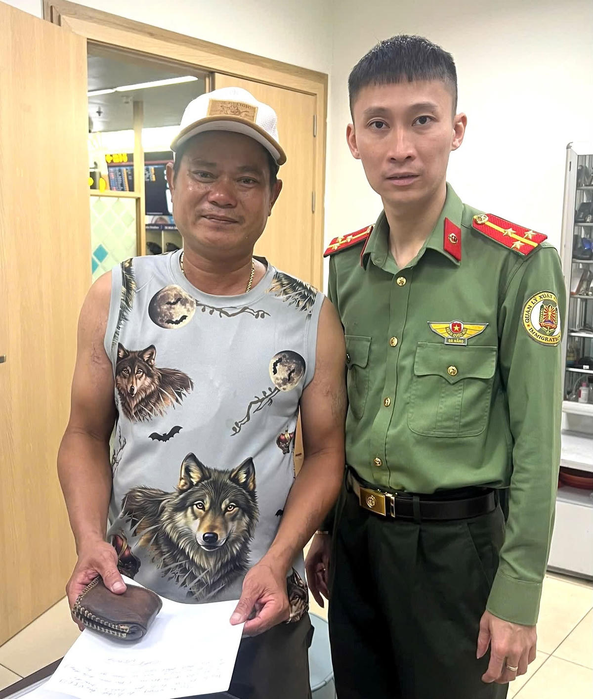 Thượng úy Nguyễn Ngọc Đức bàn giao 40 triệu và giấy tờ cho ông Võ Cường. Ảnh: Hồng Nhung