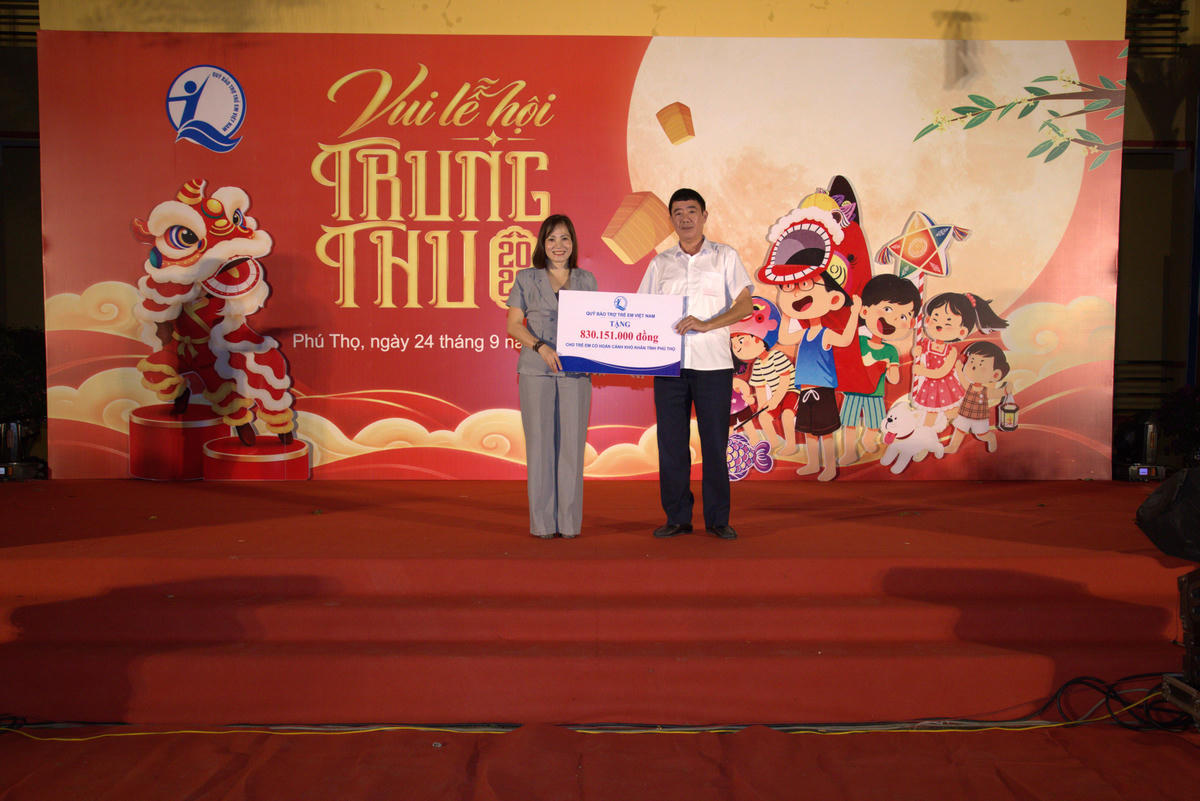 Bà Nguyễn Thị Hiền - Phó Giám đốc Quỹ BTTEVN trao biển tượng trưng hỗ trợ cho trẻ em có hoàn cảnh khó khăn tỉnh Phú Thọ. Ảnh: Vương Long