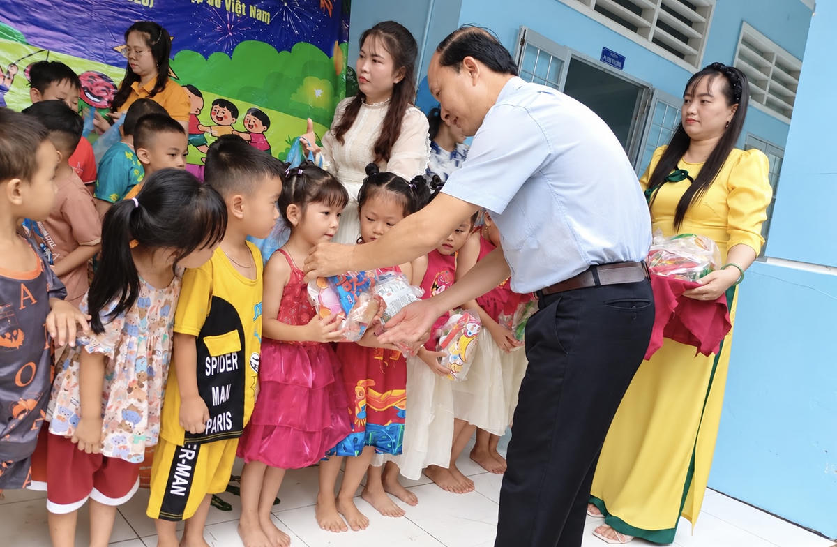 Ông Nguyễn Văn Triều, Phó Chủ tịch Thường trực Hội Chữ thập đỏ tỉnh Vĩnh Long trao quà Trung thu tặng thiếu nhi. (Ảnh: Hoàng Anh).
