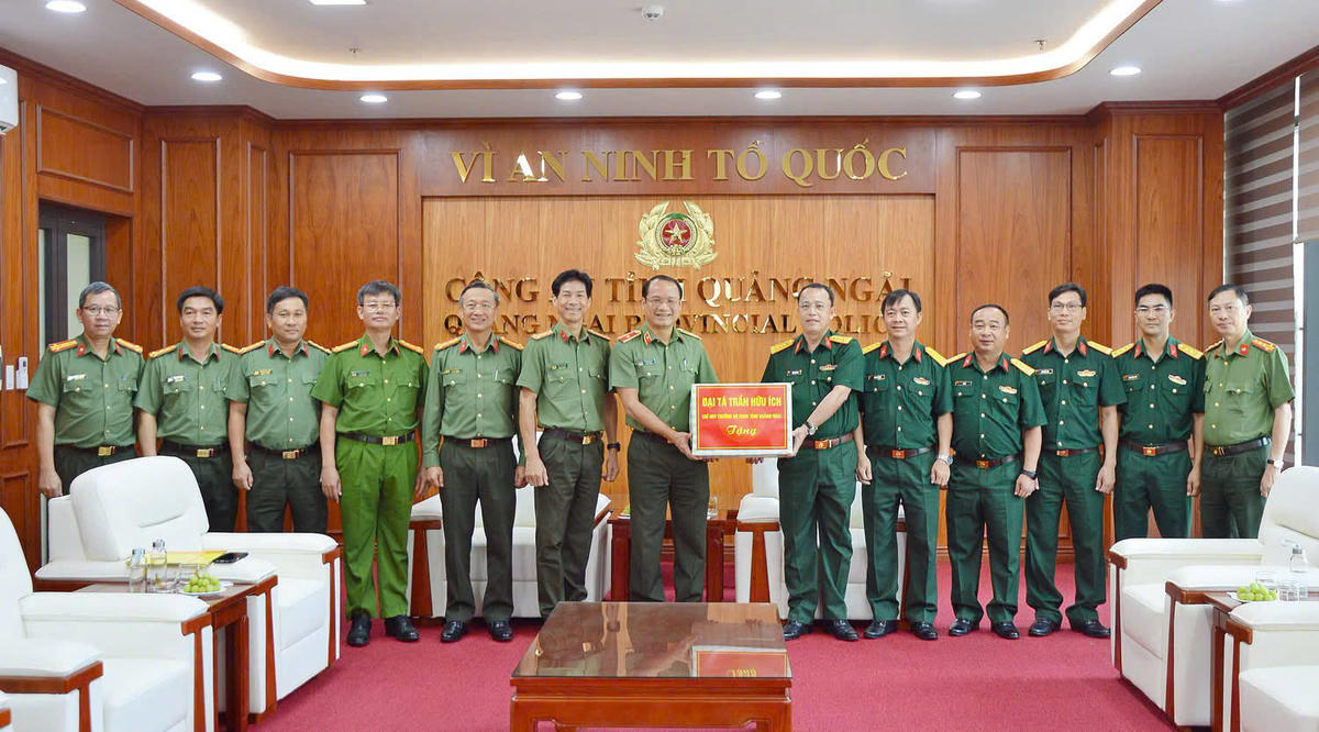 Đại tá Trần Hữu Ích, (bên phải) Chỉ huy trưởng Bộ CHQS tỉnh Quảng Ngãi tặng quà cho Công an tỉnh. Ảnh: TT.