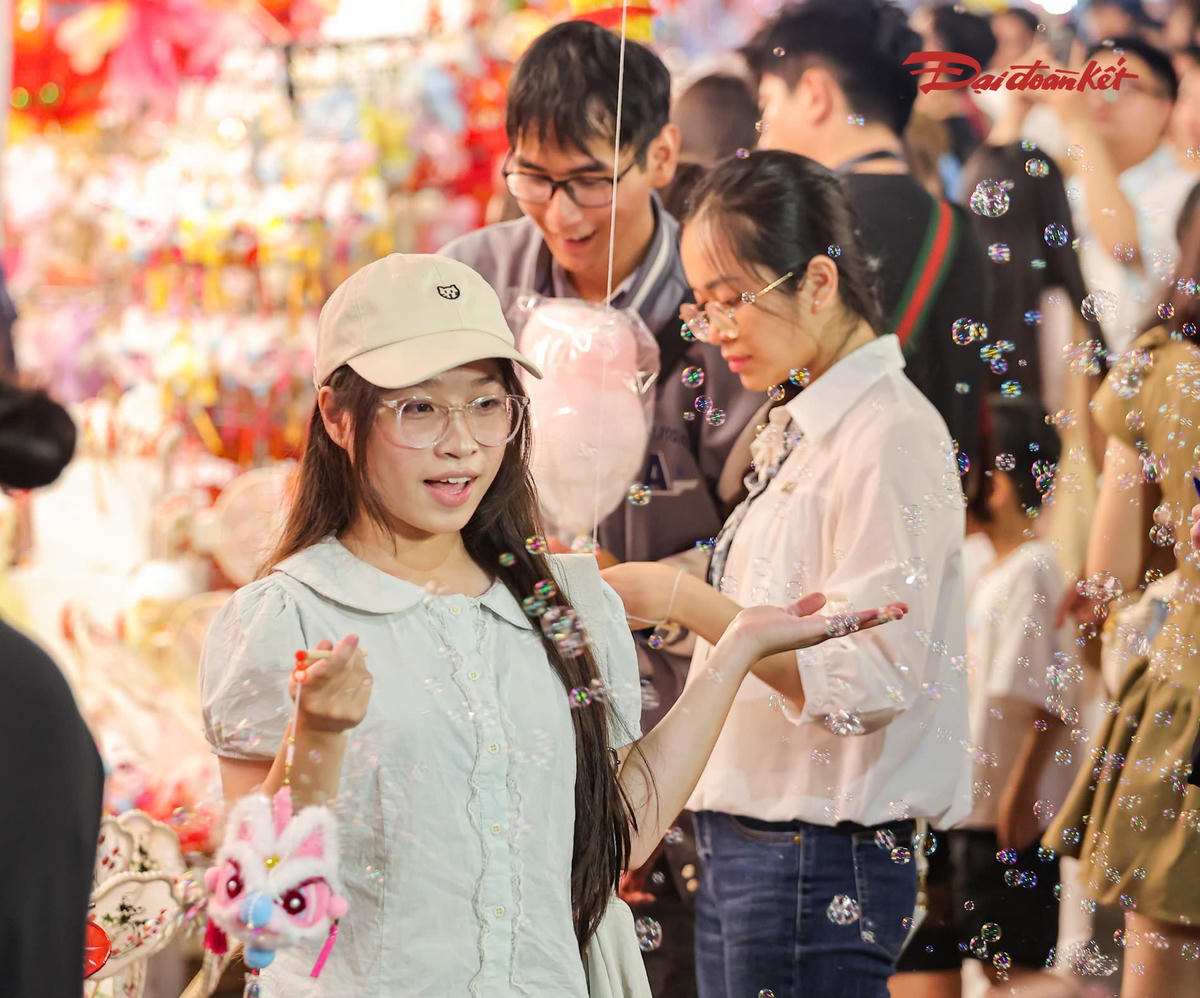 Nhiều nhóm bạn trẻ đi theo từng tốp, vừa tham quan, mua sắm vừa tranh thủ chụp ảnh lưu niệm. Một số khu vực trước các cửa hàng đông kín người, việc di chuyển khá chậm.