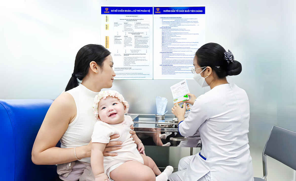 Chị Trần Thị Nga, phường Bình Đông, TPHCM đưa con gái là bé Nguyễn Trần Thiên Ý, 6 tháng tuổi đến VNVC Quận 8 tiêm vắc xin phòng tay chân miệng. Ảnh: Trung Thái