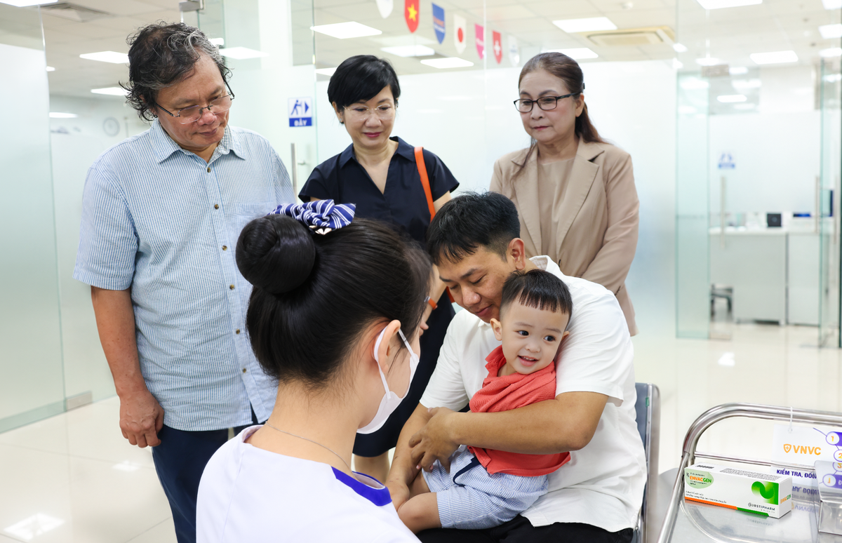 Bác sĩ Trương Hữu Khanh - người có hàng chục năm gắn bó công tác điều trị các ca tay chân miệng nặng tại Việt Nam chứng kiến mũi vắc xin phòng EV71 đầu tiên được tiêm cho trẻ tại VNVC. Ảnh: Nhân Lê