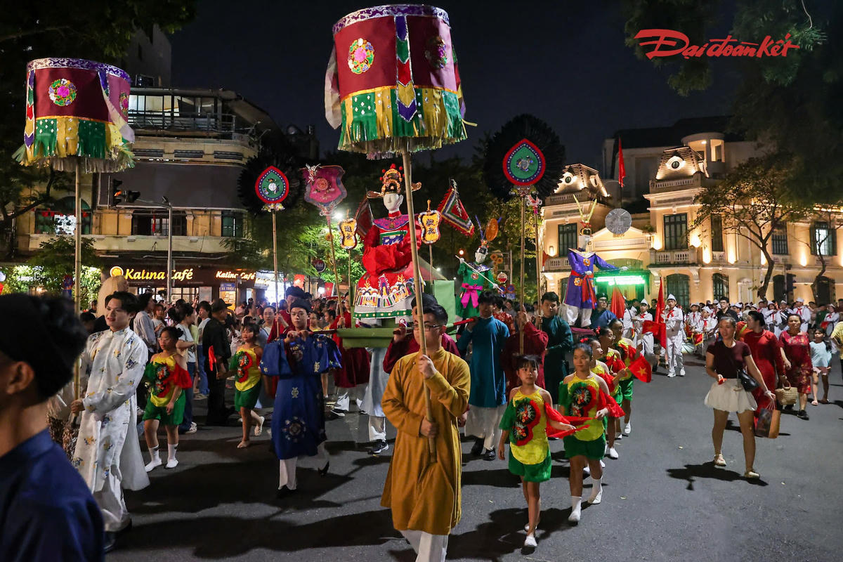 Dòng người đứng hai bên tuyến đường theo dõi đoàn rước. Nhiều bạn trẻ liên tục dùng điện thoại ghi lại hình ảnh, quay video không khí Trung thu.