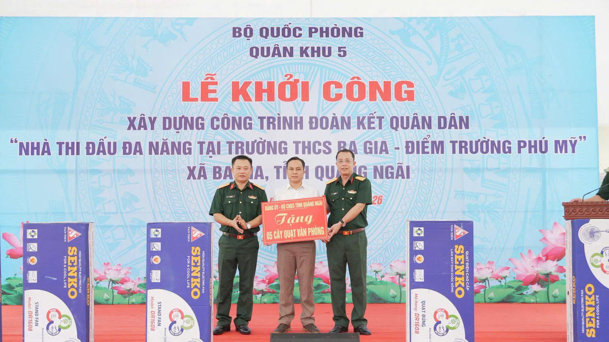 Đại tá Trần Hữu Ích (bên phải), Chỉ huy trưởng Bộ CHQS tỉnh Quảng Ngãi tặng quà cho Ban giám hiệu nhà Trường THCS Ba Gia. Ảnh: QS.