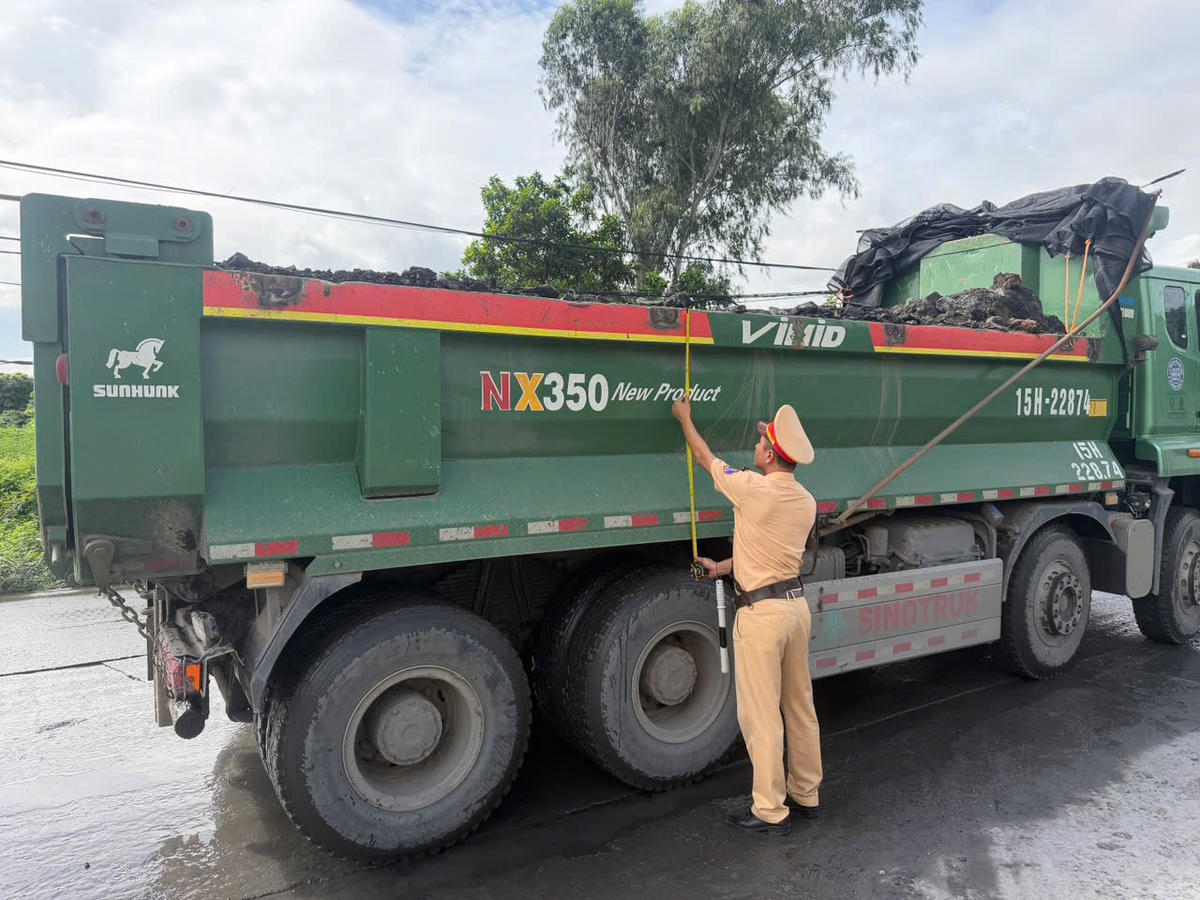 Cán bộ Đội CSGT đường bộ số 1 kiểm tra kích thước thành thùng xe tải. Ảnh: Công an TP Quảng Ninh.