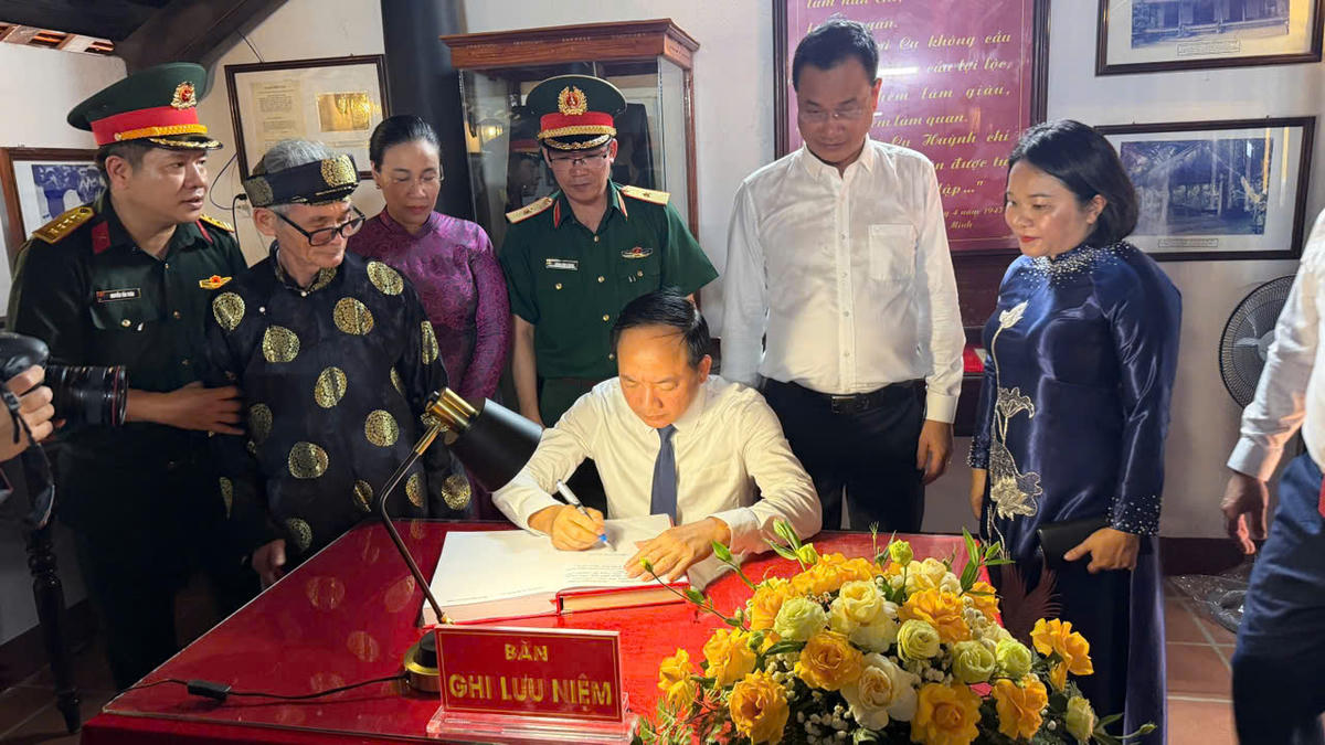 Trưởng Ban Tuyên giáo Trung ương Trịnh Văn Quyết viết sổ lưu niệm. Ảnh: Nguyễn Tín.