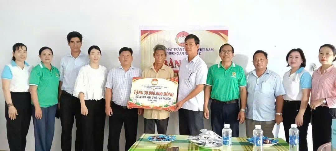Lãnh đạo Ủy ban MTTQ Việt Nam các phường An Nhơn Bắc trao tặng quà cho người dân. Ảnh: ĐS.