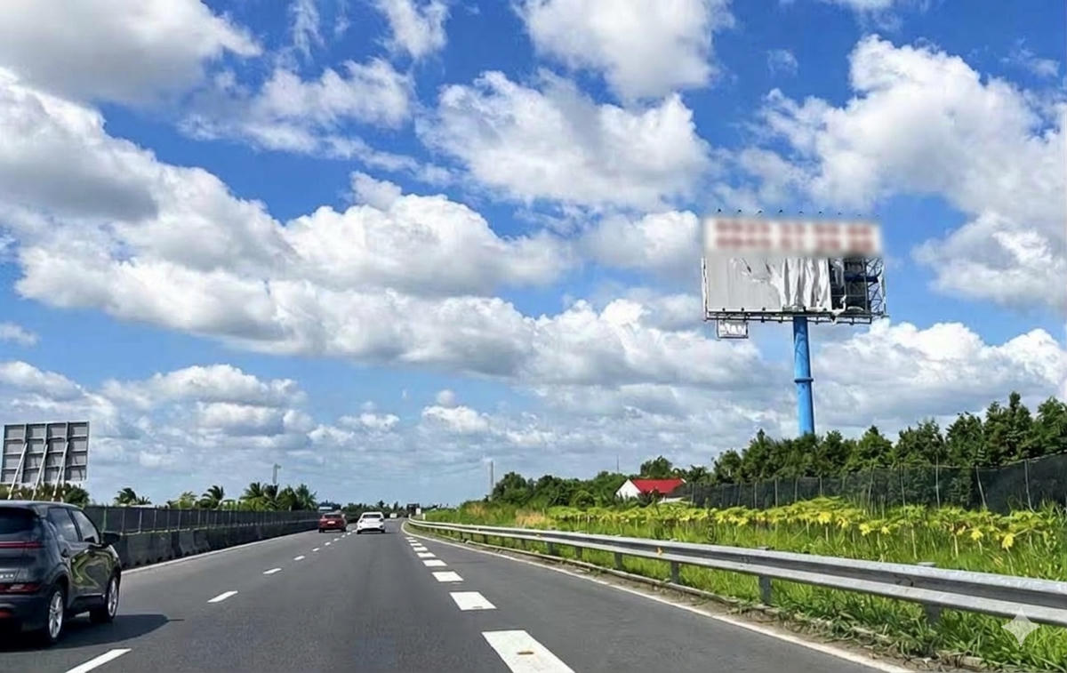 Biển quảng cáo khổ lớn cạnh cao tốc Mỹ Thuận - Cần Thơ, đoạn qua tỉnh Vĩnh Long bị bong tróc. (Ảnh: Trung Ngãi).