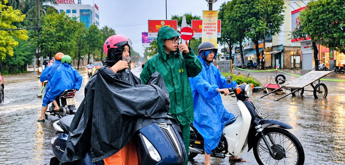 Cán bộ, chiến sĩ của Ban chỉ huy quân sự phường Tam Kỳ hướng dẫn người dân lưu thông qua đoạn đường ngập nước. Ảnh: CĐ.