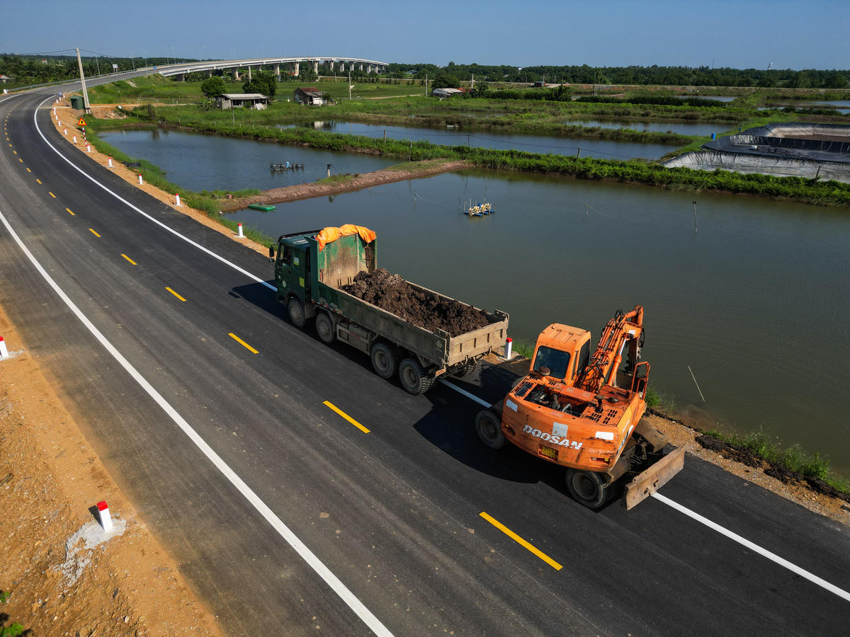 Tại khu vực tiếp giáp tỉnh Ninh Bình, các hạng mục như đắp lề đường, dựng cọc tiêu, sơn phản quang, vạch kẻ đường đang được hoàn thiện. Cùng với đó, hệ thống điện chiếu sáng và đèn tín hiệu giao thông cũng đang được triển khai. Ảnh: Đình Minh