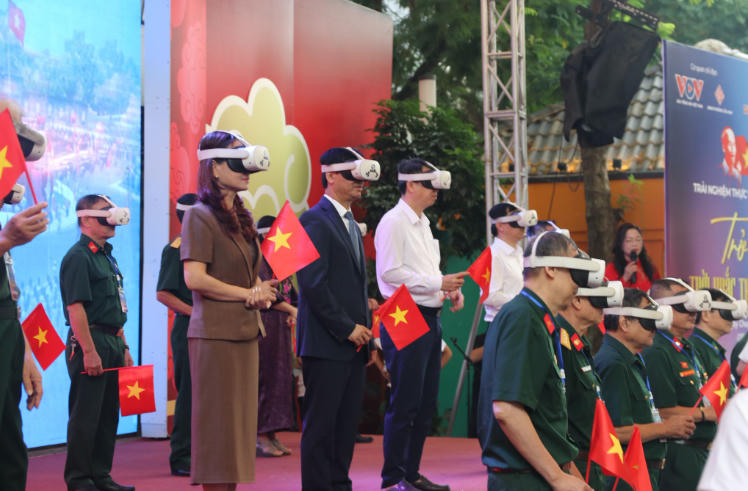 Các vị quan khách cùng các cựu chiến binh trải nghiệm công nghệ thực tế ảo (VR), tái hiện thời khắc lịch sử ngày 2/9/1945. Ảnh: Ngọc Linh.