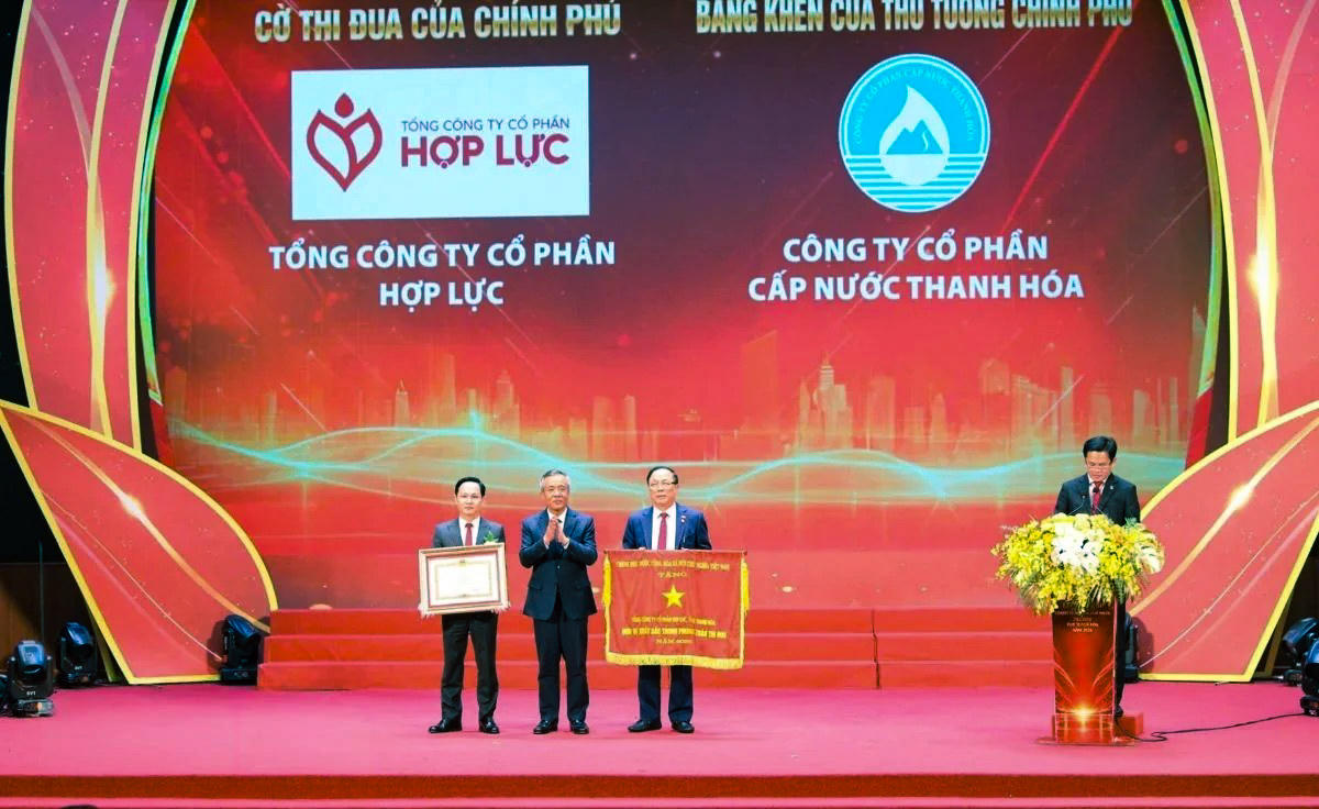 Bí thư Tỉnh ủy Lê Đức Thái trao cờ thi đua của Chính phủ cho Tổng công ty cổ phần Hợp Lực và bằng khen của Thủ tướng Chính phủ cho Công ty cổ phần cấp nước Thanh Hóa. Ảnh: Minh Hiếu