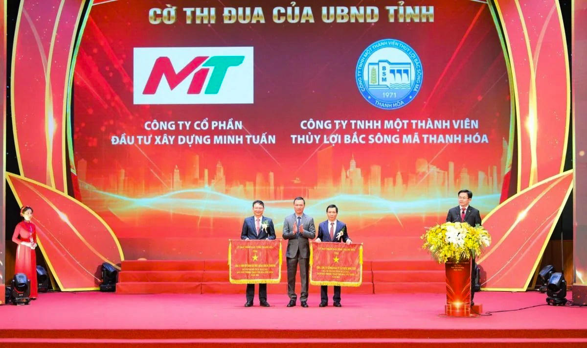 Chủ tịch UBND tỉnh Tô Anh Dũng trao cờ thi đua cho Tổng công ty cổ phần đầu tư xây dựng Minh Tuấn và Công ty TNHH MTV thủy lợi bắc sông Mã Thanh Hóa. Ảnh: Minh Hiếu