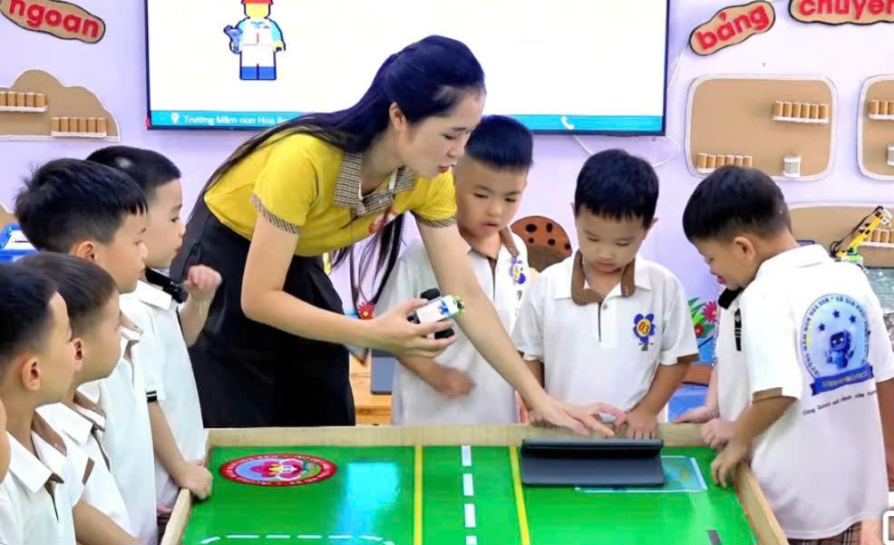 Giáo viên Trường Mầm non Hoa Ban (xã Gia Phú) đang hướng dẫn học sinh lắp robot và sử dụng máy tính bảng. Ảnh: THGP.