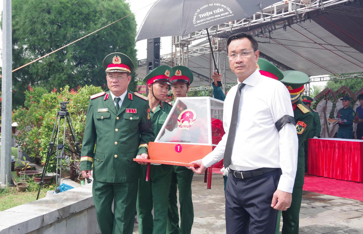 Ông Lê Ngọc Quang (bên phải), Bí thư Thành ủy Đà Nẵng đang đưa an táng hài cốt liệt sĩ. Ảnh: TT.