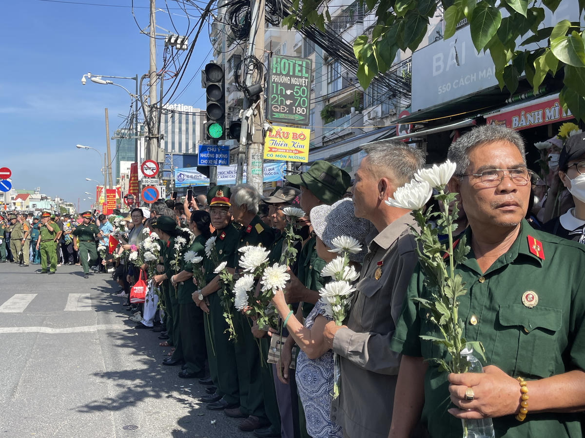 Người dân cầm hoa trắng tiễn đưa Anh hùng liệt sĩ ở công viên Lê Thị Riêng về nơi an nghỉ
