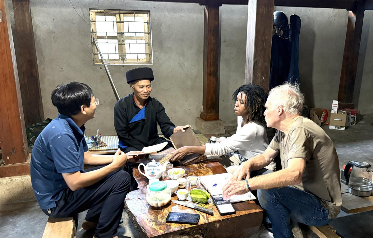 Đoàn du khách đến thăm nhà ông Lý Văn Bậu, tìm hiểu những cuốn sách chữ Dao được gia đình gìn giữ qua nhiều thế hệ.