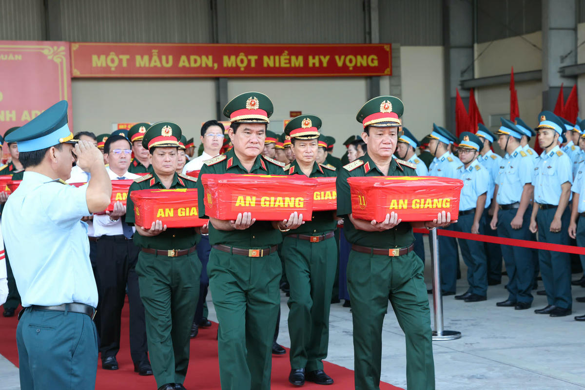 Đại diện lãnh đạo Quân khu 9 thực hiện nghi thức đưa các hài cốt liệt sĩ lên máy bay quân sự. Ảnh HT