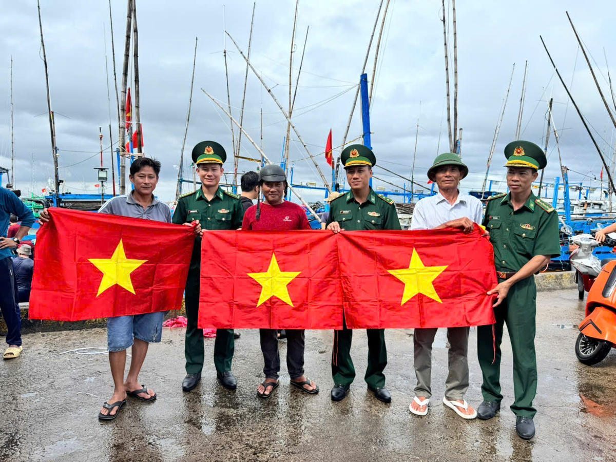 Cán bộ, chiến sĩ Đồn Biên phòng Tuy Hòa trao cờ Tổ quốc tặng ngư dân. Ảnh:NL.