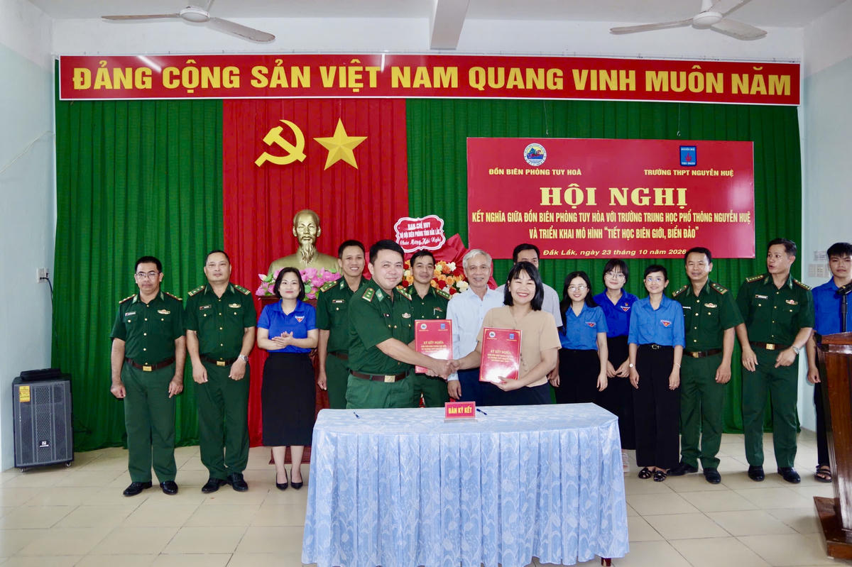 Đại diện chỉ huy Đồn Biên phòng Tuy Hòa và Trường THPT Nguyễn Huệ ký chương trình kết nghĩa. Ảnh: NL.