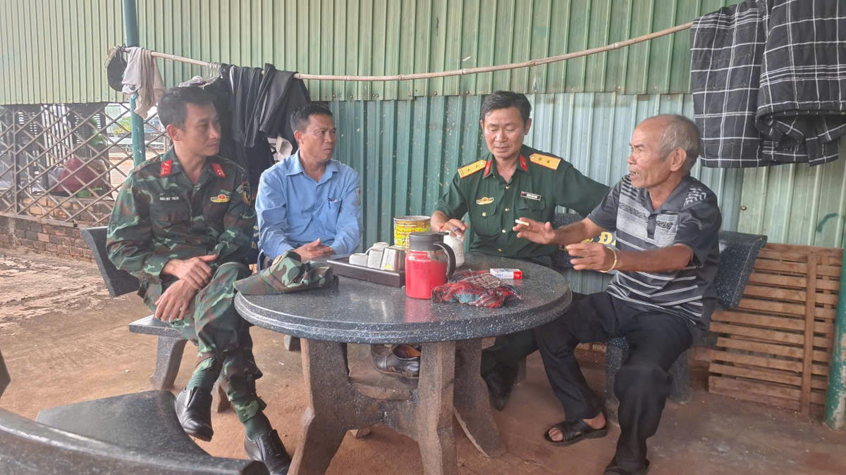 Ông Siu Pích (ngoài cùng, bên phải) cung cấp thông tin về mộ liệt sĩ cho cán bộ Đội K52.  Ảnh: HB.