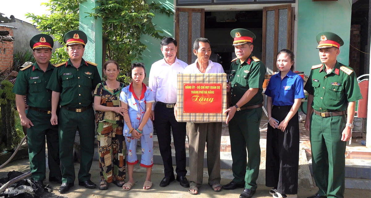 Đại tá Nguyễn Tấn Tuân, (bên phải), Phó Chính ủy Bộ CHQS TP Đà Nẵng tặng quà cho gia đình ông ông Trần Danh Tiến. Ảnh:QS.