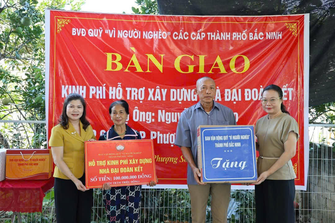 Bà Lâm Thị Hương Thành - Phó Chủ tịch HĐND TP Bắc Ninh (bên trái) và bà Thái Hải Anh - Phó Chủ tịch Ủy ban MTTQ Việt Nam TP Bắc Ninh trao kinh phí 100 triệu đồng xây dựng nhà đại đoàn kết cho gia đình ông Nguyễn Văn Đào. Ảnh: T.N.