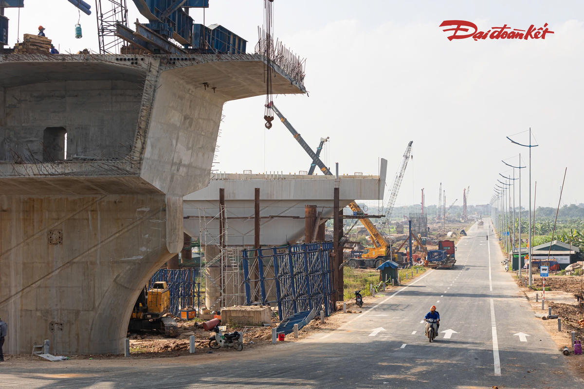 Ở phía xã Ô Diên, một phần tuyến đường dẫn lên cầu đã được thảm nhựa, kẻ vạch sơn. Tại các vị trí khác, công nhân tiếp tục gia công kết cấu thép, lắp dựng thiết bị và triển khai những hạng mục phục vụ thi công trụ, dầm cầu.