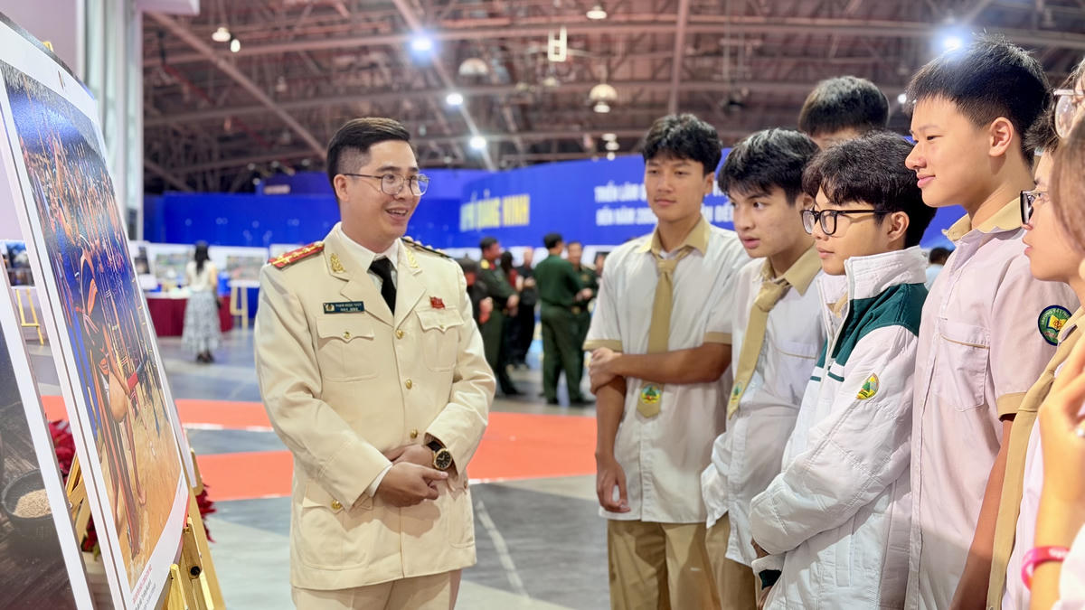 Các em học sinh tham quan, tìm hiểu và nghe giới thiệu về các tác phẩm được trưng bày tại Triển lãm ảnh.