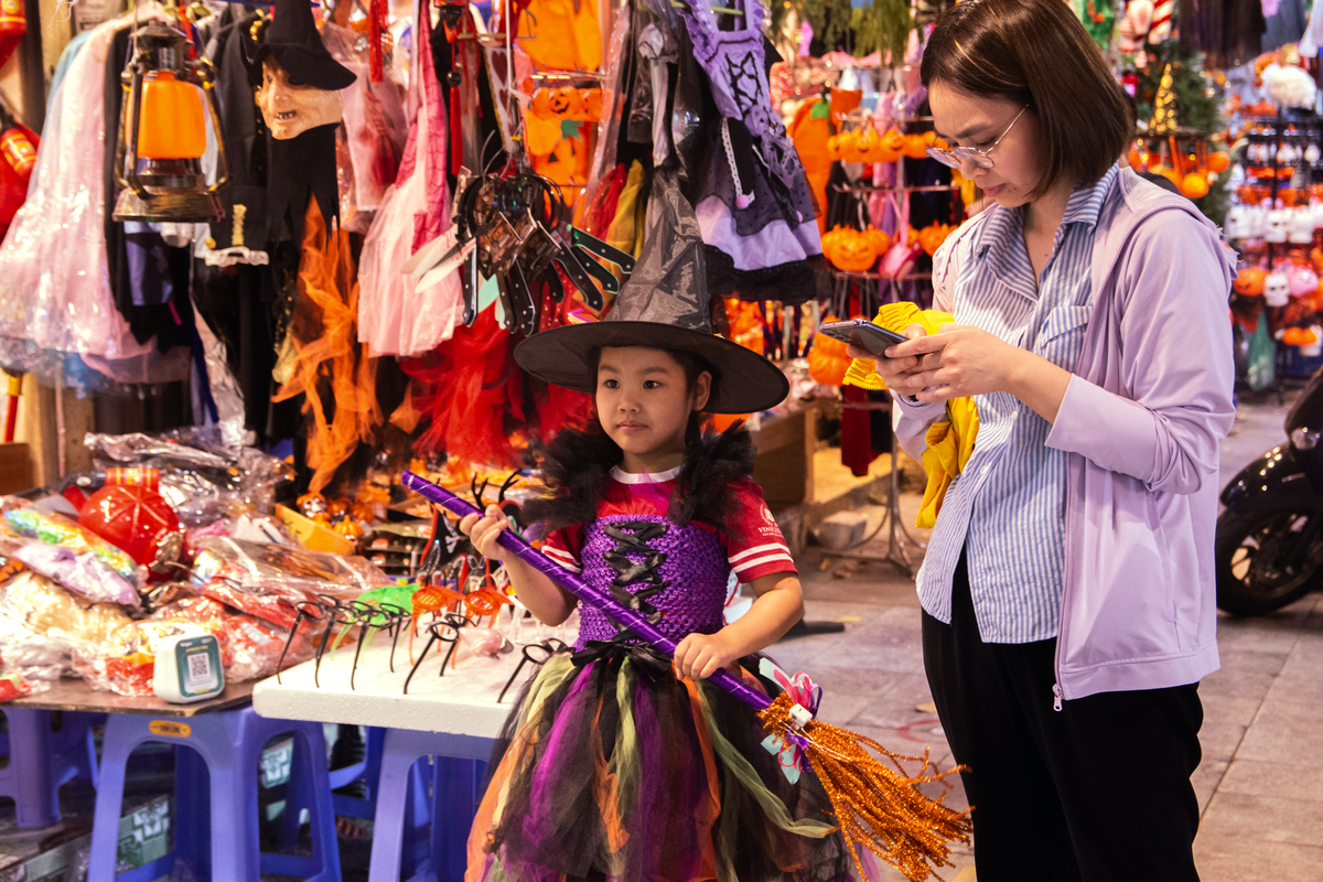 Nhiều phụ huynh đưa con đến phố Hàng Mã lựa chọn trang phục, phụ kiện cho dịp Halloween. Những chiếc mũ phù thủy, mặt nạ và bộ đồ hóa trang nhiều màu sắc thu hút sự chú ý của các em nhỏ.