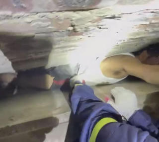 Với lấy điện thoại, người đàn ông mắc kẹt giữa khe tường