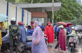 Phụ huynh 'đội mưa' chờ con thi tốt nghiệp THPT 2023