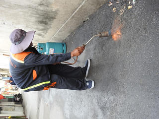 Đà Nẵng: Khò lửa ga để vá lại đường vừa thảm nhựa đã bong tróc do mưa 