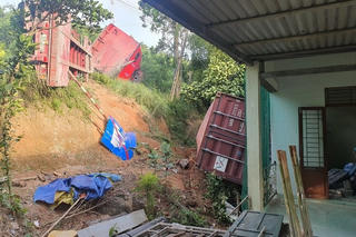 Xe đầu kéo bị lật trên Quốc lộ, thùng container bay vào nhà dân