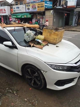 Ô tô đậu trước lối vào nhà dân bị đổ rác đầy nắp ca pô