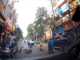 [VIDEO] Vừa lái xe máy vừa dùng điện thoại, cô gái gặp ngã đập đầu vào bánh xe ô tô